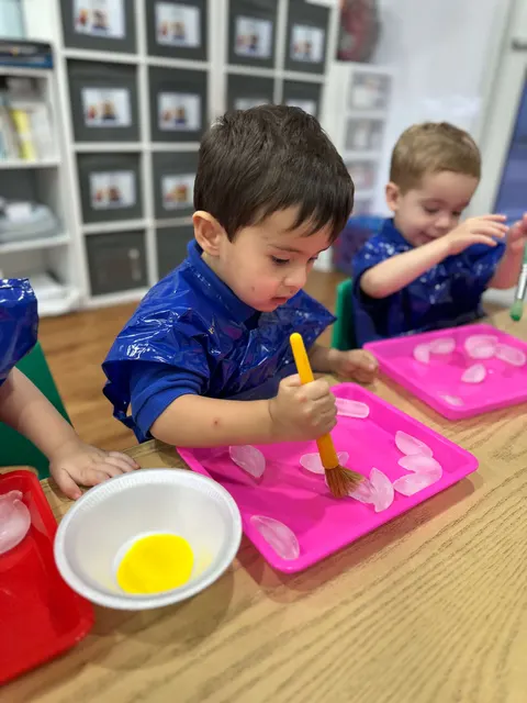 A boy in a blue Bufi polo painting with a yellow brush