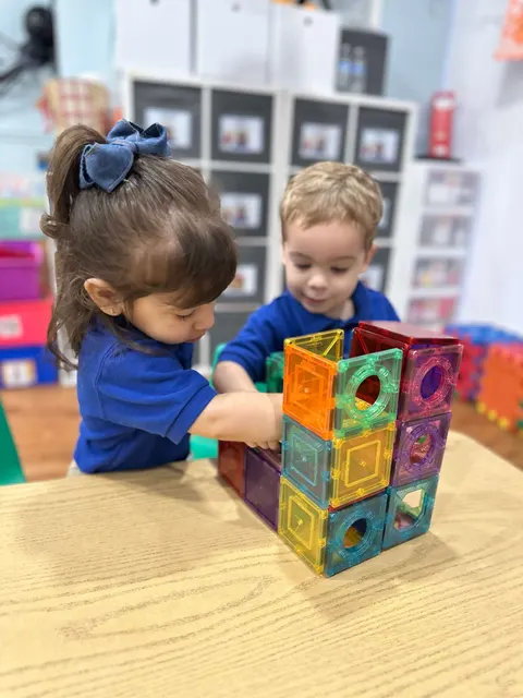 Toddlers building with magnetic tiles